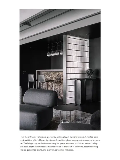 A publication feature showcasing the interplay of light and texture at the entrance of the Vaulted Haus. The frosted glass brick partition diffuses light into a soft, ambient glow, separating the entrance from the bar.