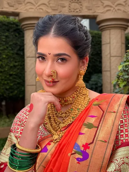 A close-up of my beautiful Maharashtrian bride. I focused on creating a warm, matte eye and lip to complement the traditional gold jewellery and Paithani saree, ensuring her natural radiance was the centerpiece.