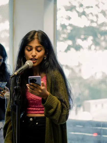 A student vocalist reading her lyrics as she performs. Our recitals are a safe space to be vulnerable and share original work.