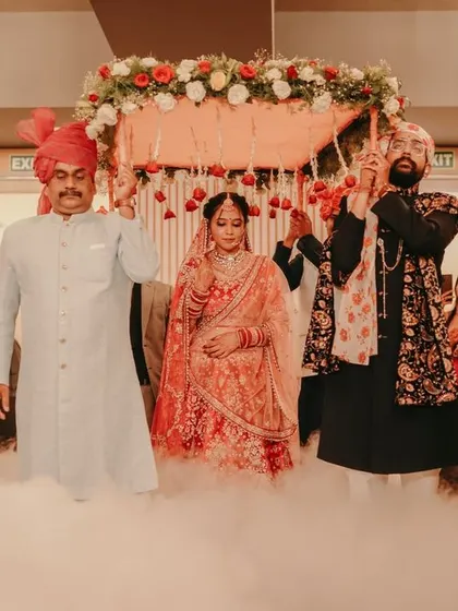 A dramatic bridal entry under a 'phoolon ki chadar', surrounded by smoke for a fairytale effect.