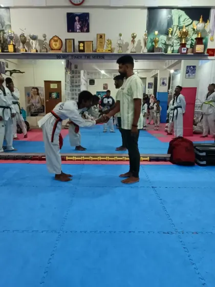 A student receives her red belt.