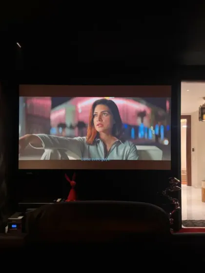 A view from the back of the home theater, showing the projector setup and how the dark walls and ceiling minimize light reflection for an optimal viewing experience.