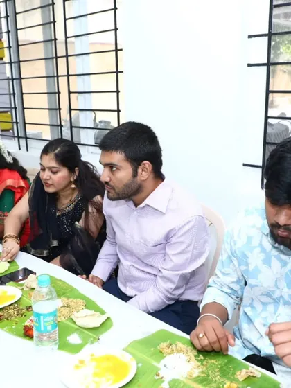 Guests engaged in conversation while enjoying their authentic South Indian meal on banana leaves.