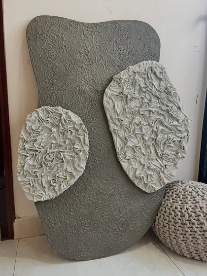 The full view of the grey sculptural piece. The organic shape of the board itself adds to the artwork's unique character, making it feel like a natural formation.