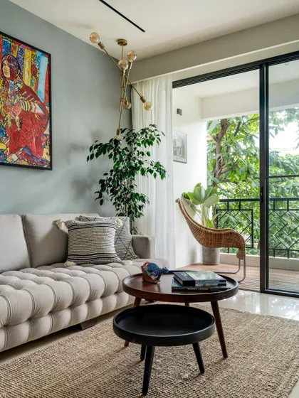 A closer look at the living room, which opens to a balcony overlooking the surrounding trees. We used a cool color palette and natural textures to create a calming atmosphere.