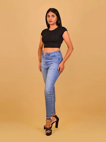 A full-length shot showing her pose and physique, with makeup kept minimal and professional.