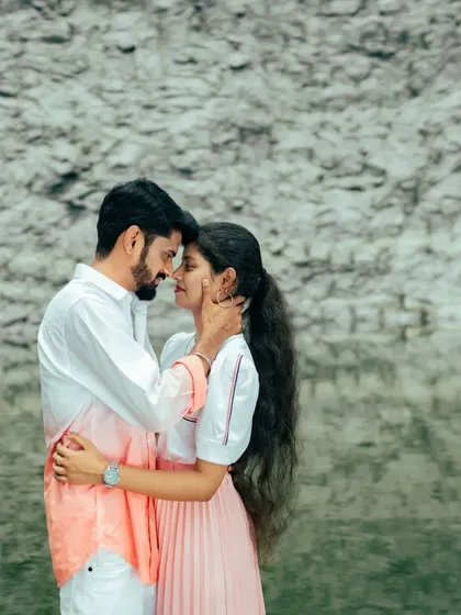 A close-up of a couple embracing, their heads together, against the backdrop of a quarry lake. A beautiful and emotional portrait.