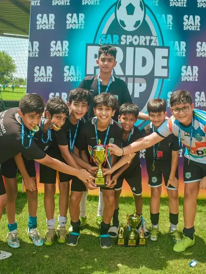 A team gathers around their collection of trophies and medals after the final.