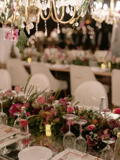 The art of celebration is in the details. This shot from a finale dinner shows our meticulous approach to tablescaping, where fresh floral arrangements, elegant glassware, and ambient lighting come together to create an unforgettable dining experience.