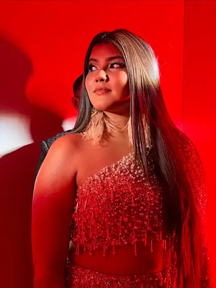 A dramatic shot with red lighting. The makeup holds up beautifully, with the highlighter catching the light perfectly.