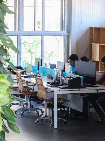Our architects at work in a bright, open workstation. The design provides ample natural light and views of greenery, creating a pleasant and productive environment for detailed design work.