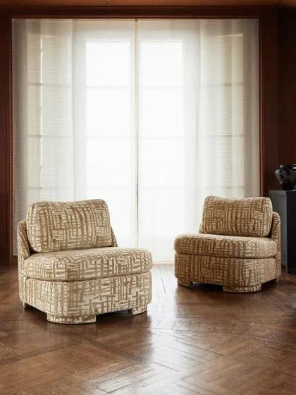Another view of the "Montana" slipper chairs, highlighting their elegant silhouette against a backdrop of rich wood and sheer drapery. This image emphasizes the chair's versatility and timeless charm within a classic architectural setting.