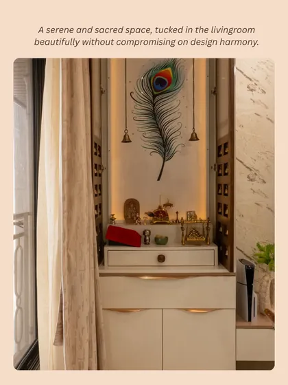 A serene and sacred space, tucked beautifully into the living room. This compact pooja unit features a peacock feather artwork and hanging bells, adding to the design harmony.