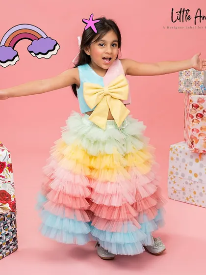 This multicolored skirt and top set features a rainbow of ruffles and a large yellow bow.