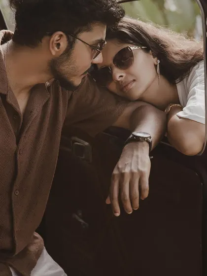 A close-up of a couple sharing an intimate moment in a vintage car.
