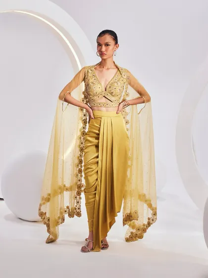The LYDIA Cape Set, crafted from fine weaves and luxurious textiles. The set is an amalgamation of a breezy cape, an embellished blouse, and a pre-drape solid skirt.