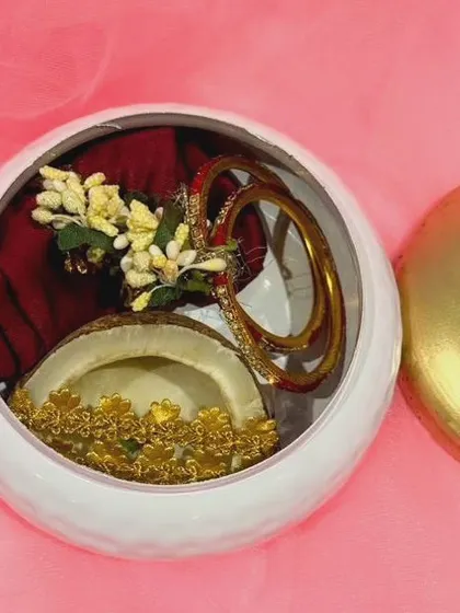 Another perspective of the open box, focusing on the arrangement of the bangles and the floral accent on the blouse piece.
