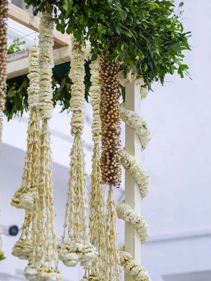 A close-up of traditional Indian floral hangings, made from delicate white jasmine and other fragrant flowers.