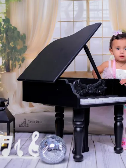 Our 'Mini Musician' theme is perfect for little princesses too. Dressed in a lovely pink gown, she looks right at home next to the piano, surrounded by elegant props like lanterns and a disco ball.