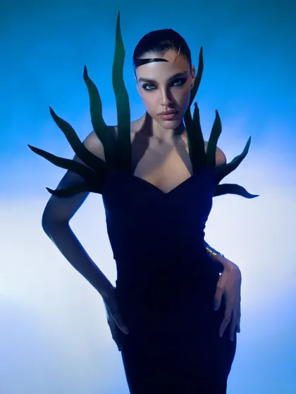 An avant-garde portrait with sculptural elements and intense, colored lighting. This image is designed to be a showstopper in any high-fashion portfolio.