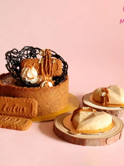 A full display of my Biscoff cheesecake offerings. You can see the larger cake perfect for a party, alongside the individual heart-shaped mini cheesecakes that are great for gifting or as part of a dessert table.