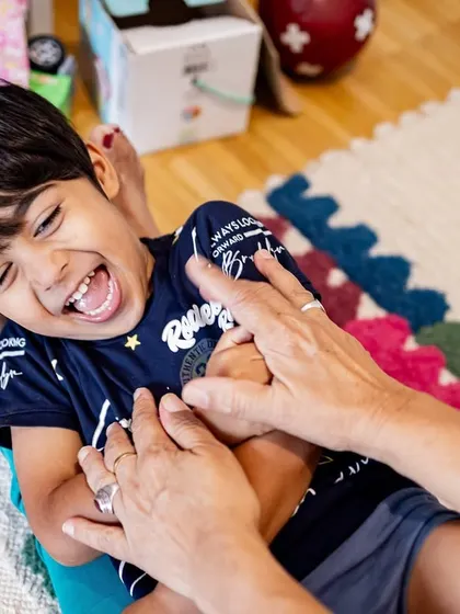 Pure, unrestrained laughter! A candid moment of a boy being tickled on the living room floor. These are the real, joy-filled memories that I aim to preserve for your family.