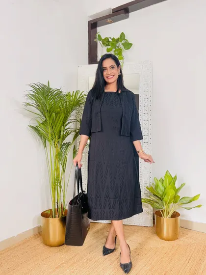 A classic black dress with a matching cropped jacket. This is a versatile workwear outfit that is both professional and stylish.