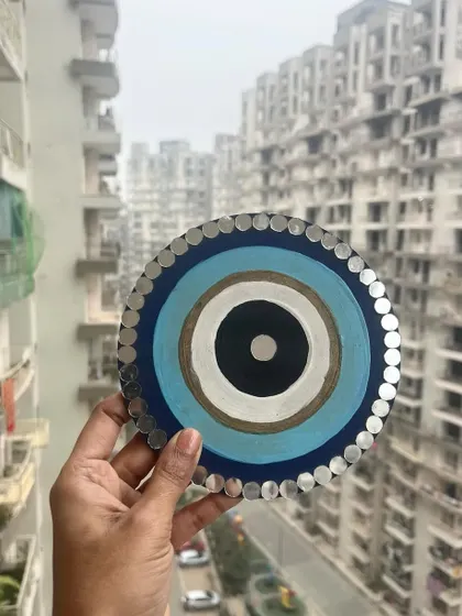 A large, hand-painted Evil Eye wall hanging with mirror work, designed to protect your home and keep your happiness private.