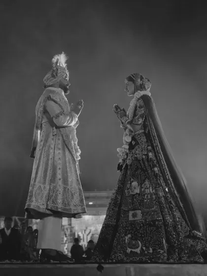 A powerful black and white silhouette of the couple during the varmala ceremony. This artistic shot captures the grandeur and timelessness of the moment as they stand before their loved ones.