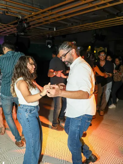A candid shot of a couple mid-dance, smiling and connected. These are the moments we cherish.