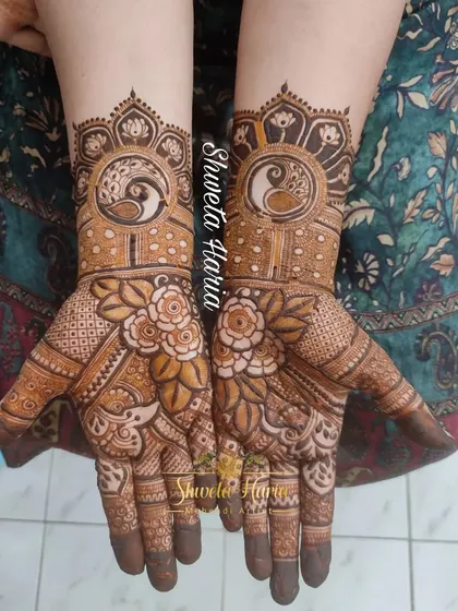 A beautiful design for the bride's mom, featuring peacock and lotus mandalas on the back of the hands, surrounded by floral details.
