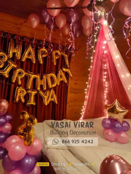We love creating romantic surprises! This bedroom decoration features a dreamy pink canopy with fairy lights over the bed, surrounded by pink and purple balloons. The personalized "Happy Birthday Riya" foil balloons make the celebration feel extra special.