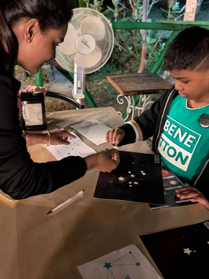 A child creates their own glow in the dark constellation art. This hands on craft lets kids take a piece of the night sky home with them.