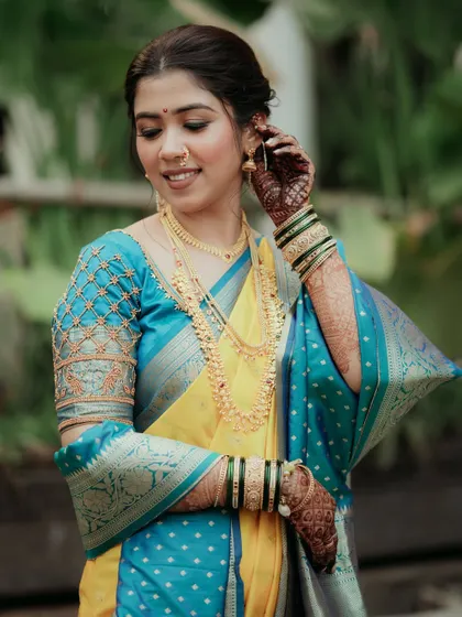This bride's look for her Maharashtrian wedding features a beautiful yellow and turquoise saree, complemented by soft, elegant makeup.