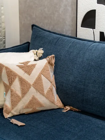A close-up of the textured cushion on the navy sofa, showing how we use textiles to add warmth and detail to a minimalist design.