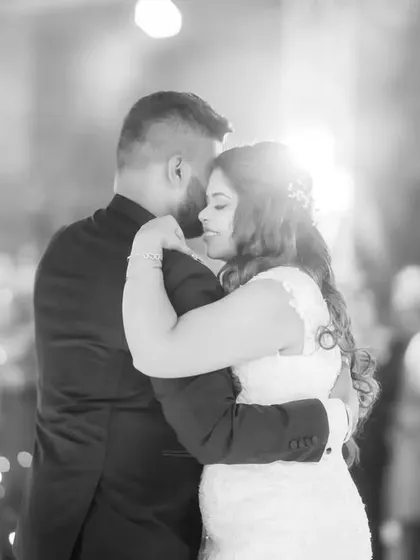 A romantic black and white shot of the couple's first dance, with sparklers in the background. The lighting creates a magical, high-contrast scene.
