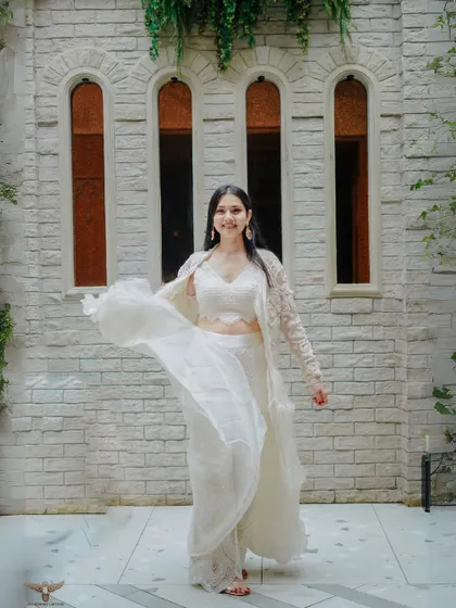 A beautiful solo shot of the bride-to-be, her flowing white outfit creating a sense of movement and grace. The heritage-style building in the background adds a touch of timeless elegance to this pre-wedding portrait.