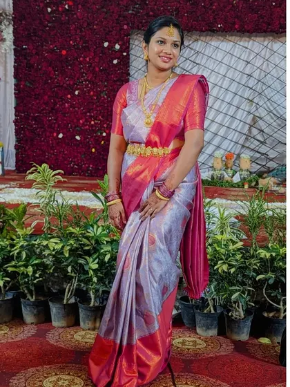 A full view of a non-bridal makeover for a friend's wedding. The makeup is elegant and understated, allowing the vibrant pink and silver silk saree to be the star of the show.