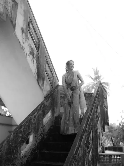 The bride pauses on the stairs, her smile captured in a beautiful black and white candid moment.
