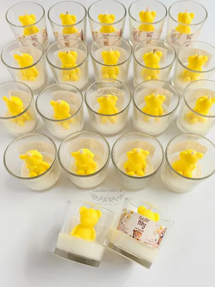 An array of the adorable yellow teddy bear votive candles, ready to be packaged as memorable return gifts for a special baby shower.