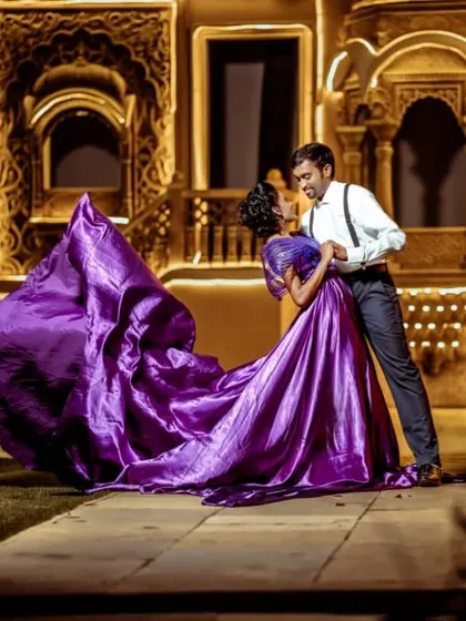 A dance under the stars. This dramatic shot captures the magic of our purple metallic gown with its flowing trail, paired with a classic suit and suspenders for a vintage Hollywood feel.