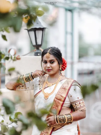 A beautiful outdoor portrait of the bride, Sumitha, on her wedding day. The soft focus on the foreground leaves creates a lovely frame.