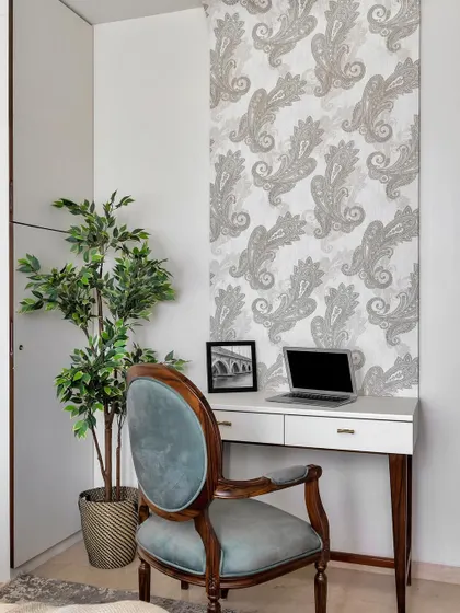 Your 9-to-5 just scored some serious style points. This chic home office corner features a classic wooden desk and a velvet-upholstered chair, set against a beautiful paisley wallpaper for an artistic touch.