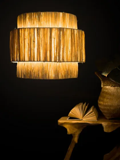 I love experimenting with different textures, and this tiered lampshade is crafted from raw natural fibers to create a rich, layered effect. When lit, it radiates a gentle, warm light that highlights the material's organic quality.