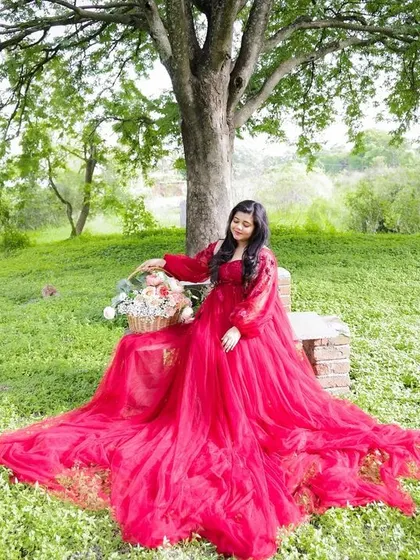 Taking the magic outdoors. This beautiful portrait was taken in a lush green park, with the vibrant red gown creating a stunning contrast against the natural scenery.