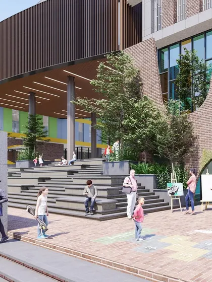 An outdoor art and activity area at Basil School. The stepped seating and paved ground with playful patterns create a flexible space for students to learn and create outside the traditional classroom.