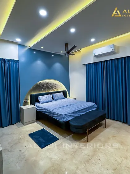A full view of the moon-themed bedroom, showcasing the dramatic effect of the blue walls, matching curtains, and the glowing headboard.