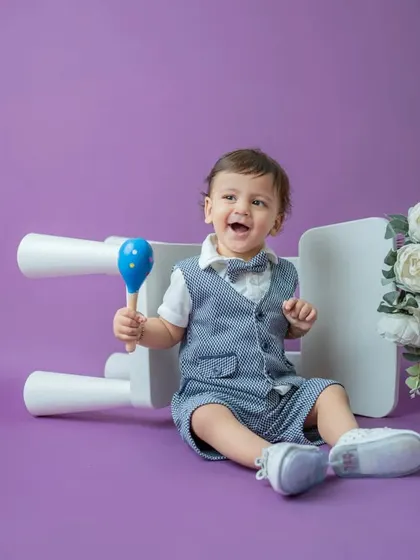 A burst of laughter from this well-dressed toddler. I love capturing these candid moments of pure joy during my classic portrait sessions.