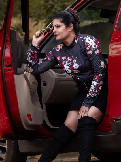 Posing with sunglasses, adding a touch of glamour to the edgy outfit.