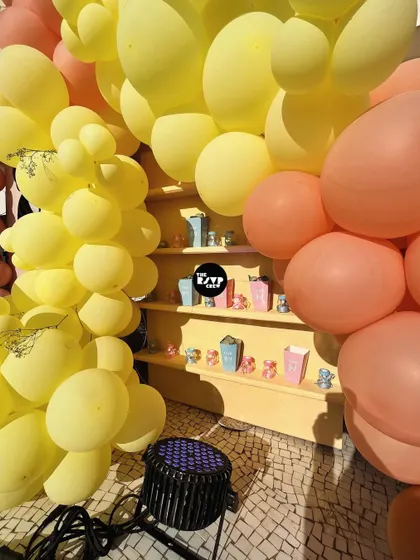A detail shot of the built-in shelving within our "Sweet as Can Bee" backdrop. The shelves are framed by yellow and peach organic balloons and are perfect for displaying party favors or small decorative items that match the theme.
